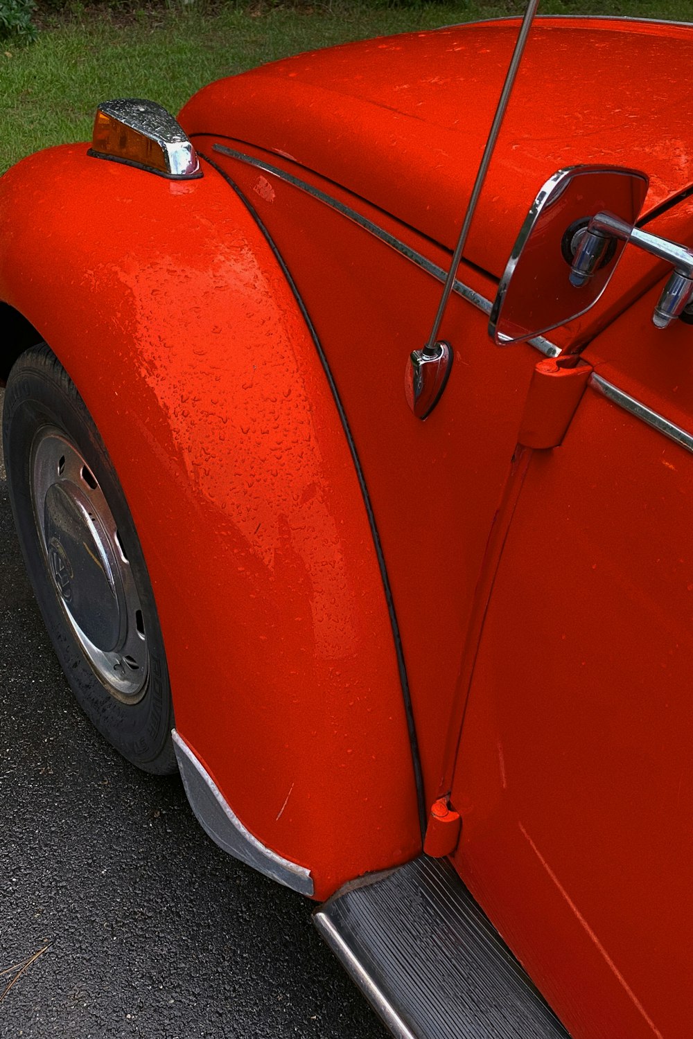 Auto rossa su strada asfaltata grigia