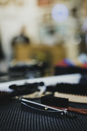 A sleek barber razor and comb resting on a wooden countertop with soft natural light.
