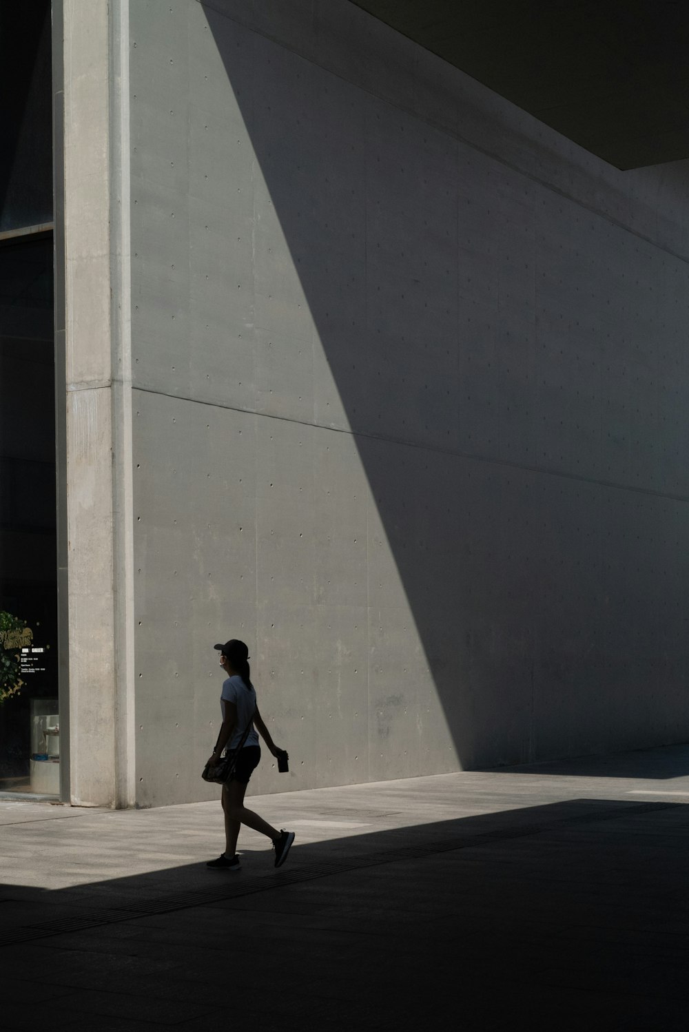 man in black jacket walking on sidewalk during daytime