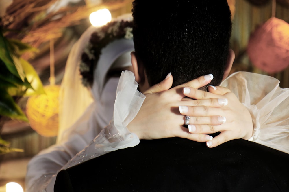 man in black shirt covering face with white textile