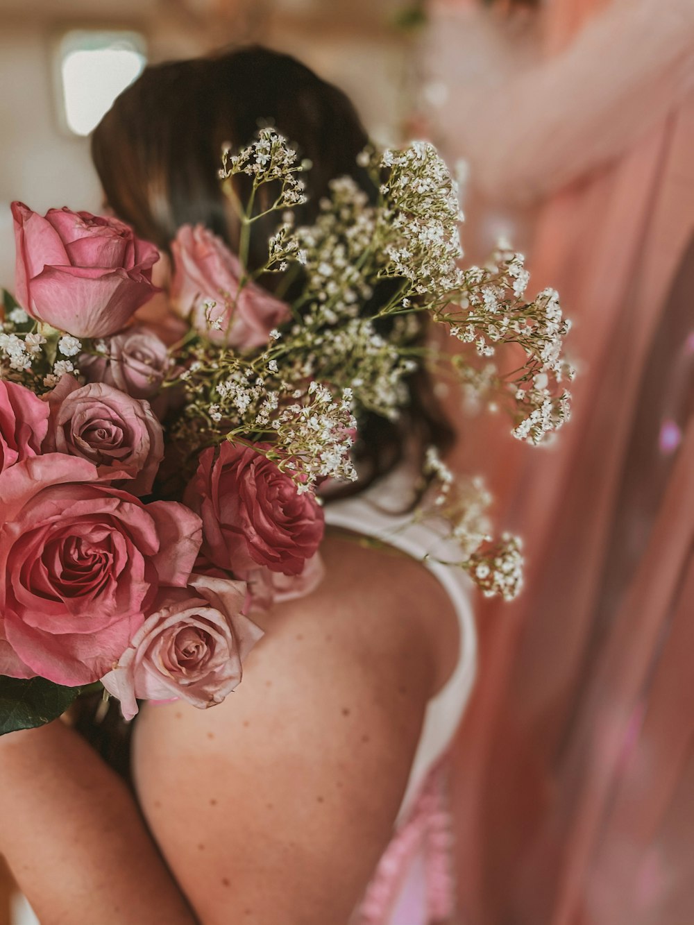 woman holding pink roses bouquet