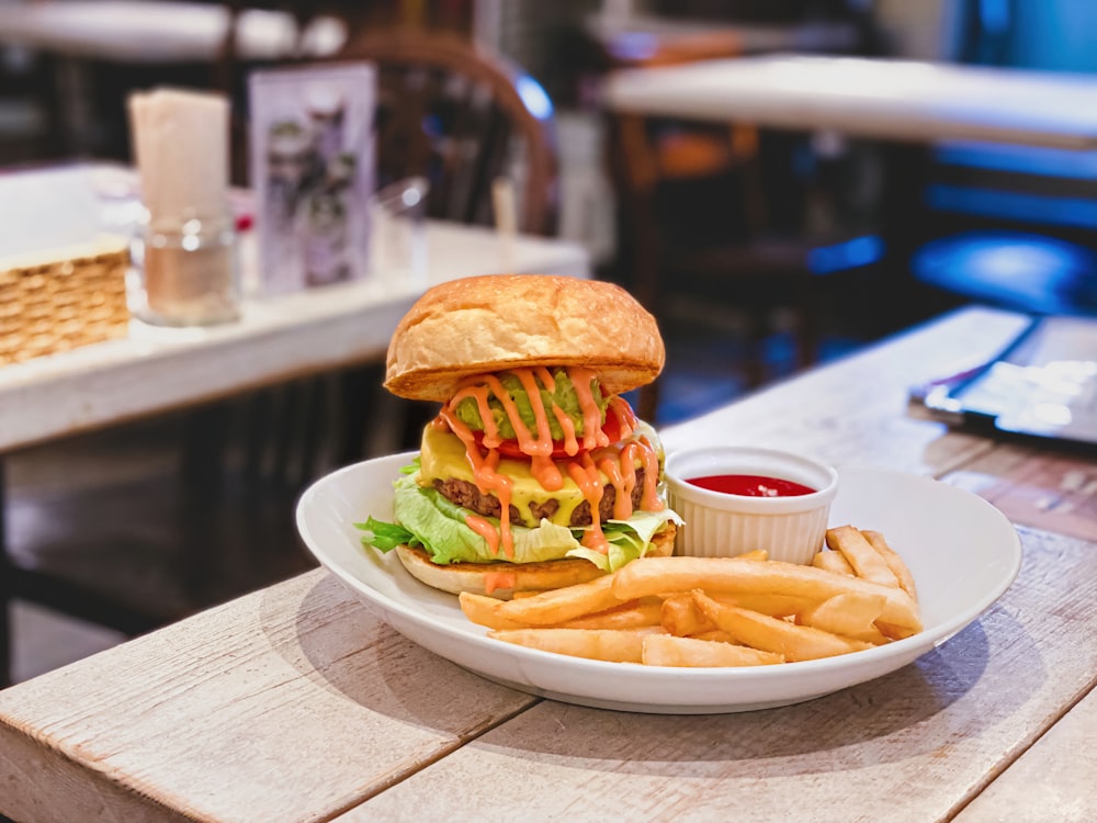 burger with lettuce and fries on white ceramic plate