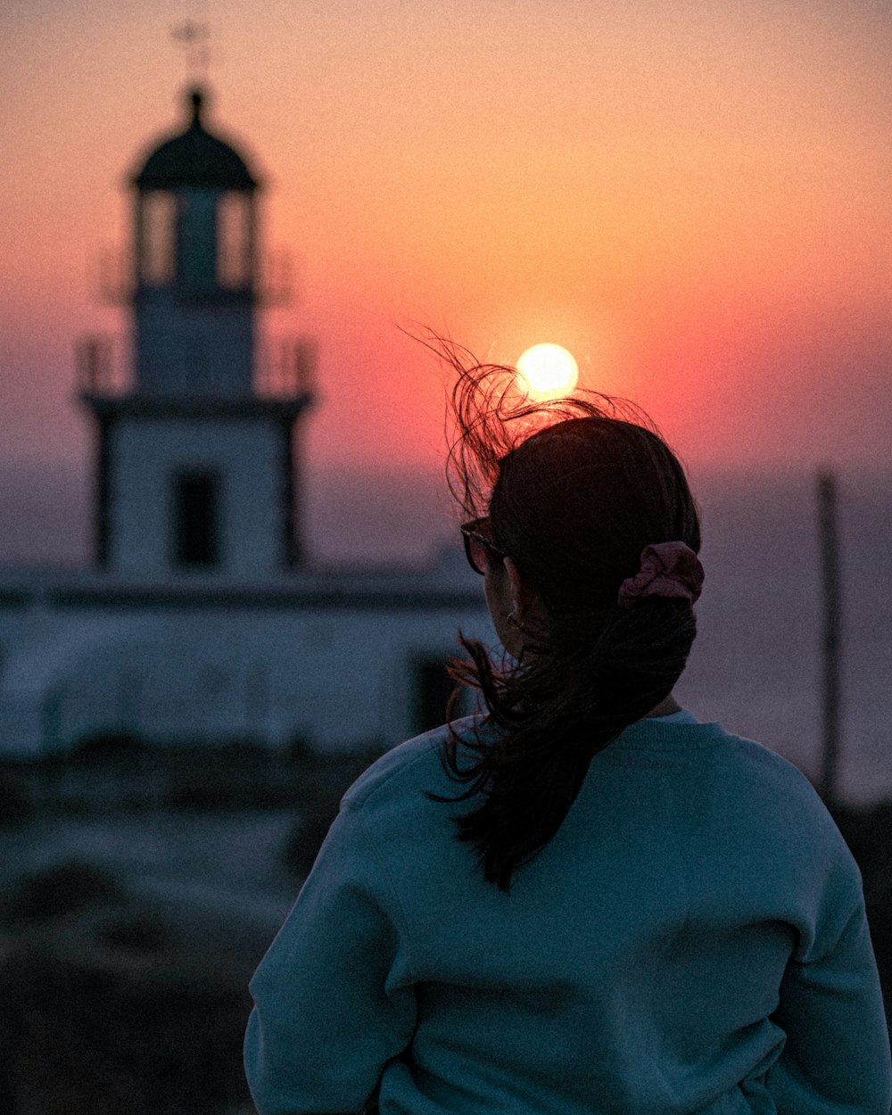 woman in white shirt standing near white building during sunset