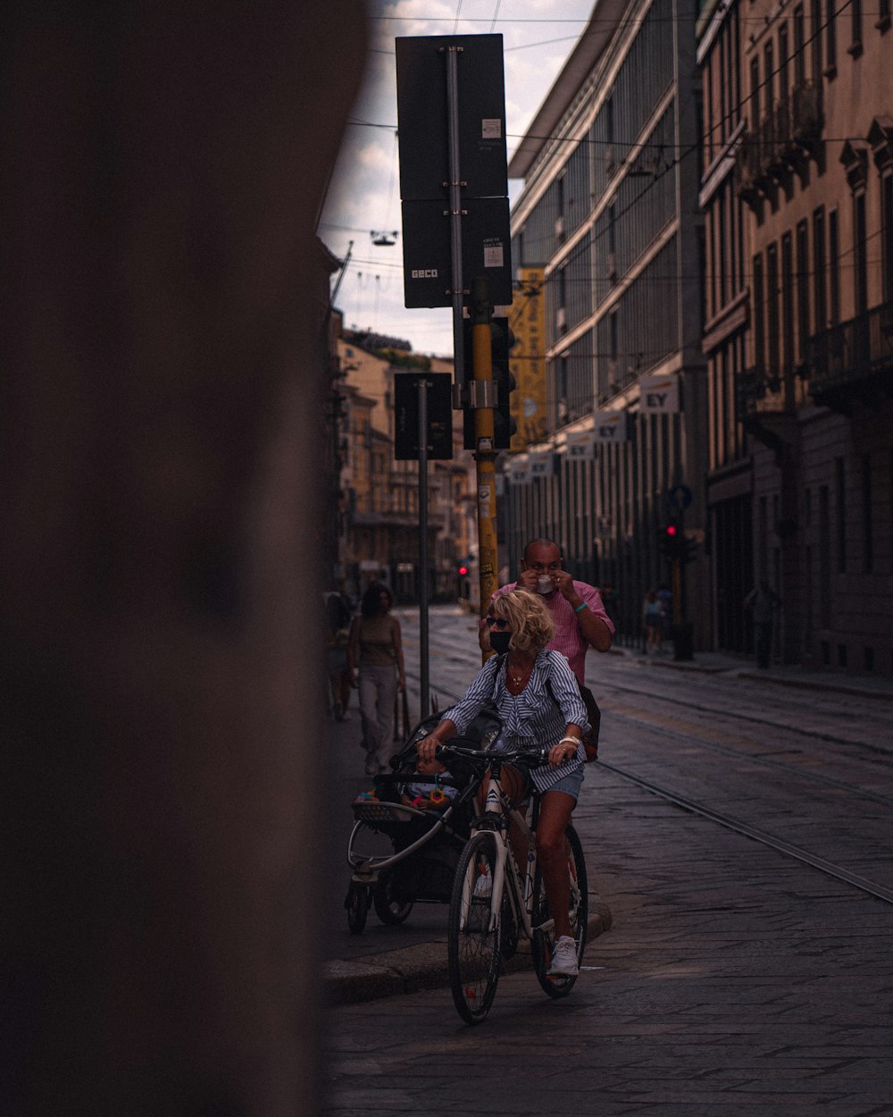 man in blue shirt riding bicycle on street during daytime