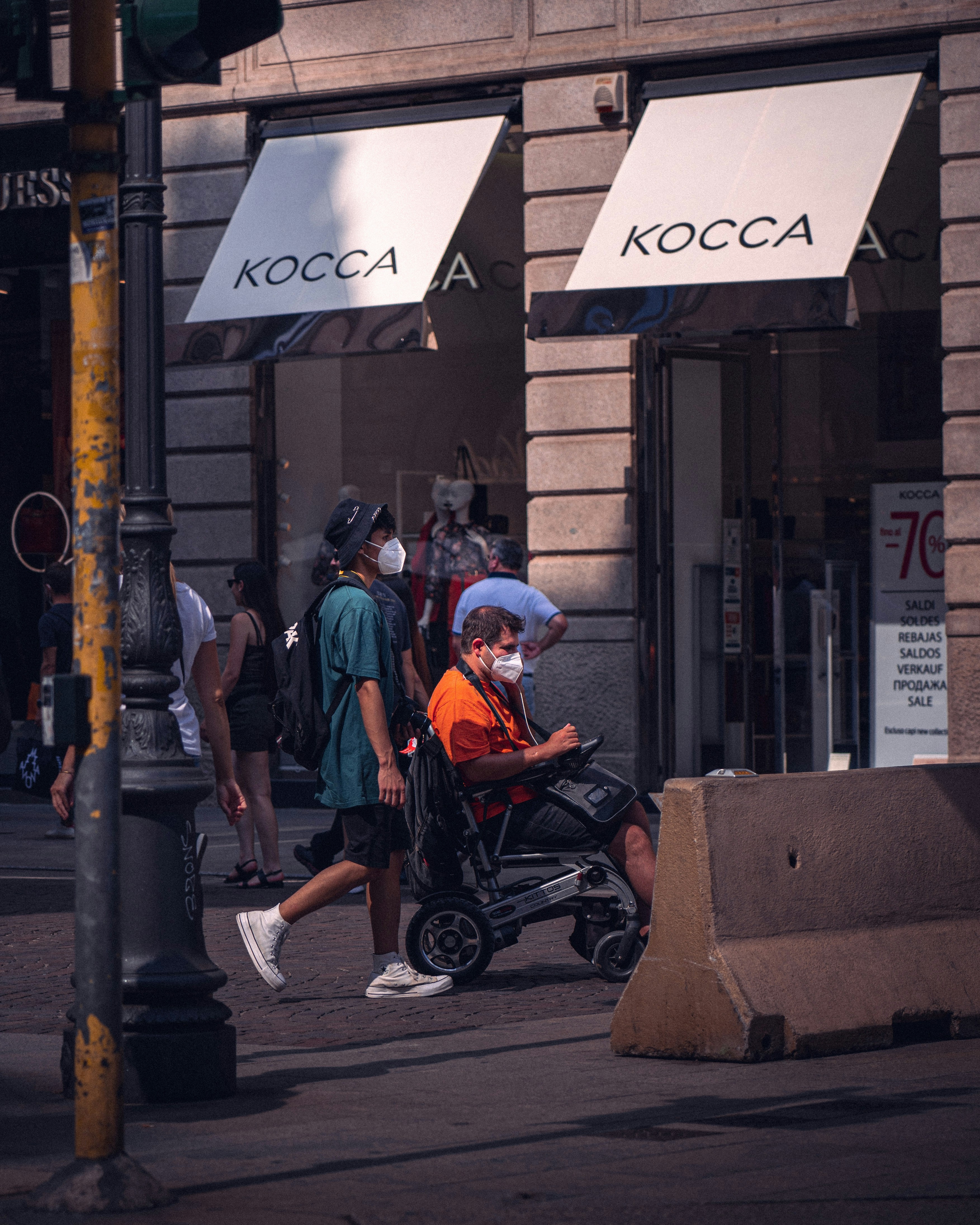 man in orange t-shirt sitting on black wheelchair