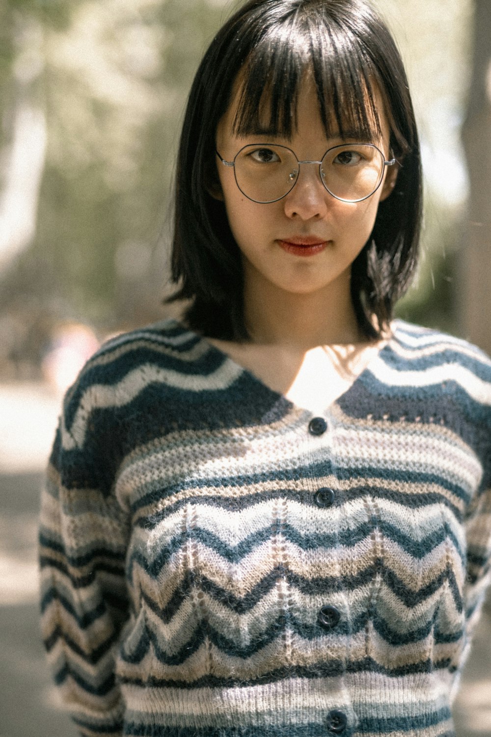 woman in white and black striped sweater wearing black framed eyeglasses