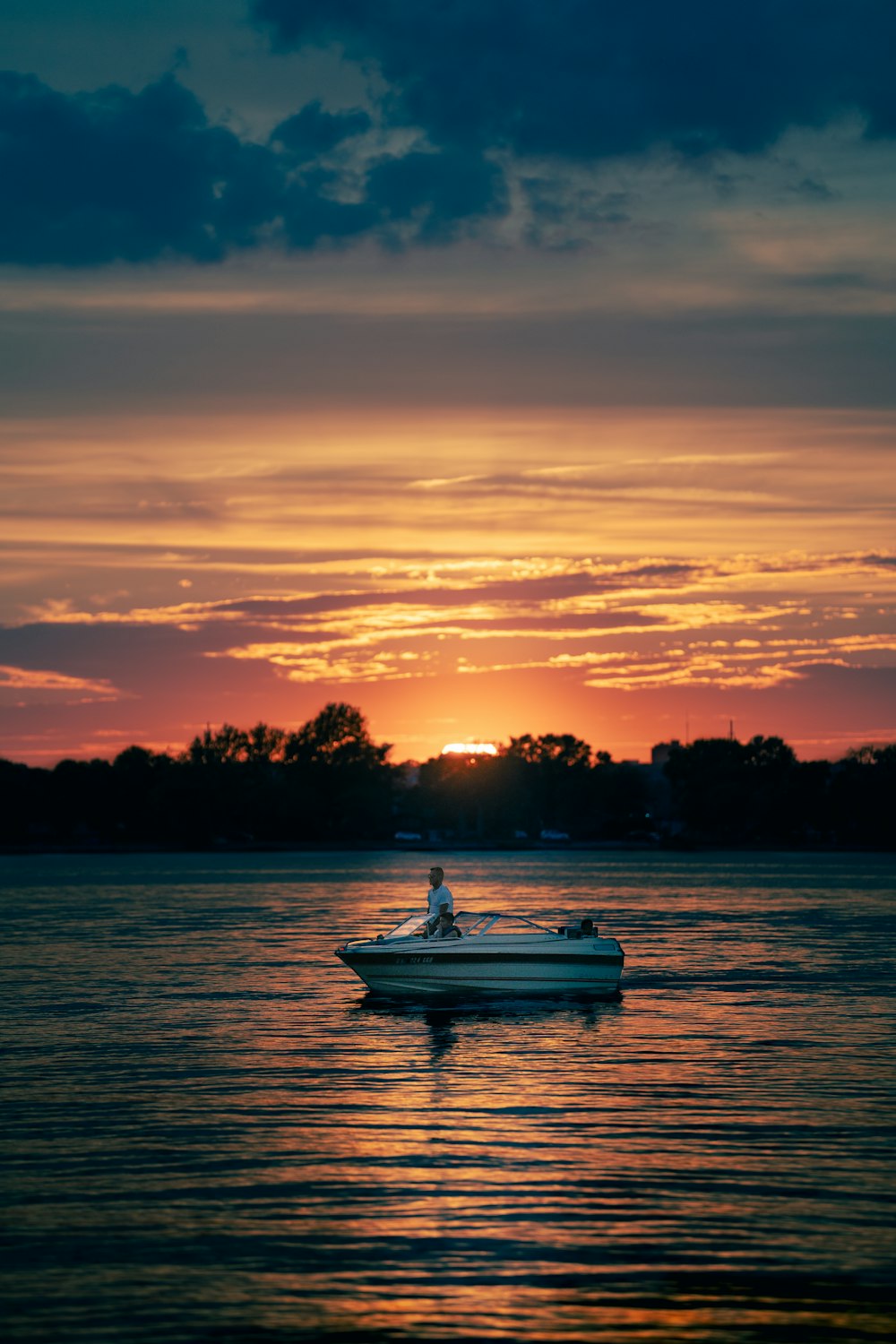 white boat on sea during sunset