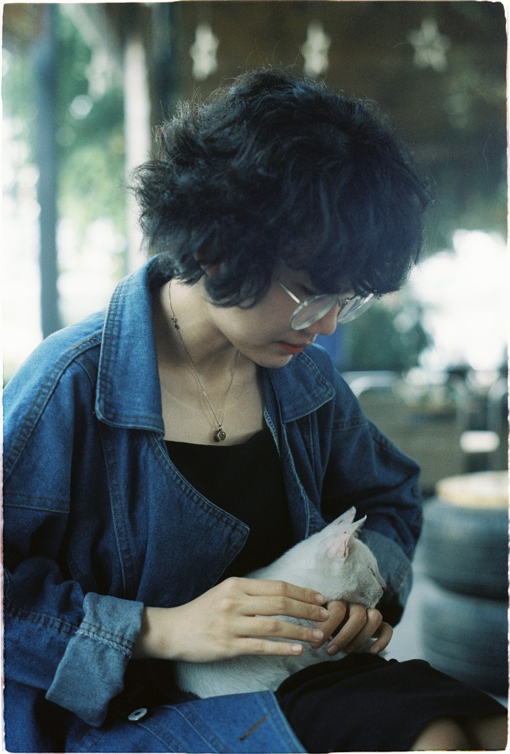 woman in blue denim jacket holding white tissue paper