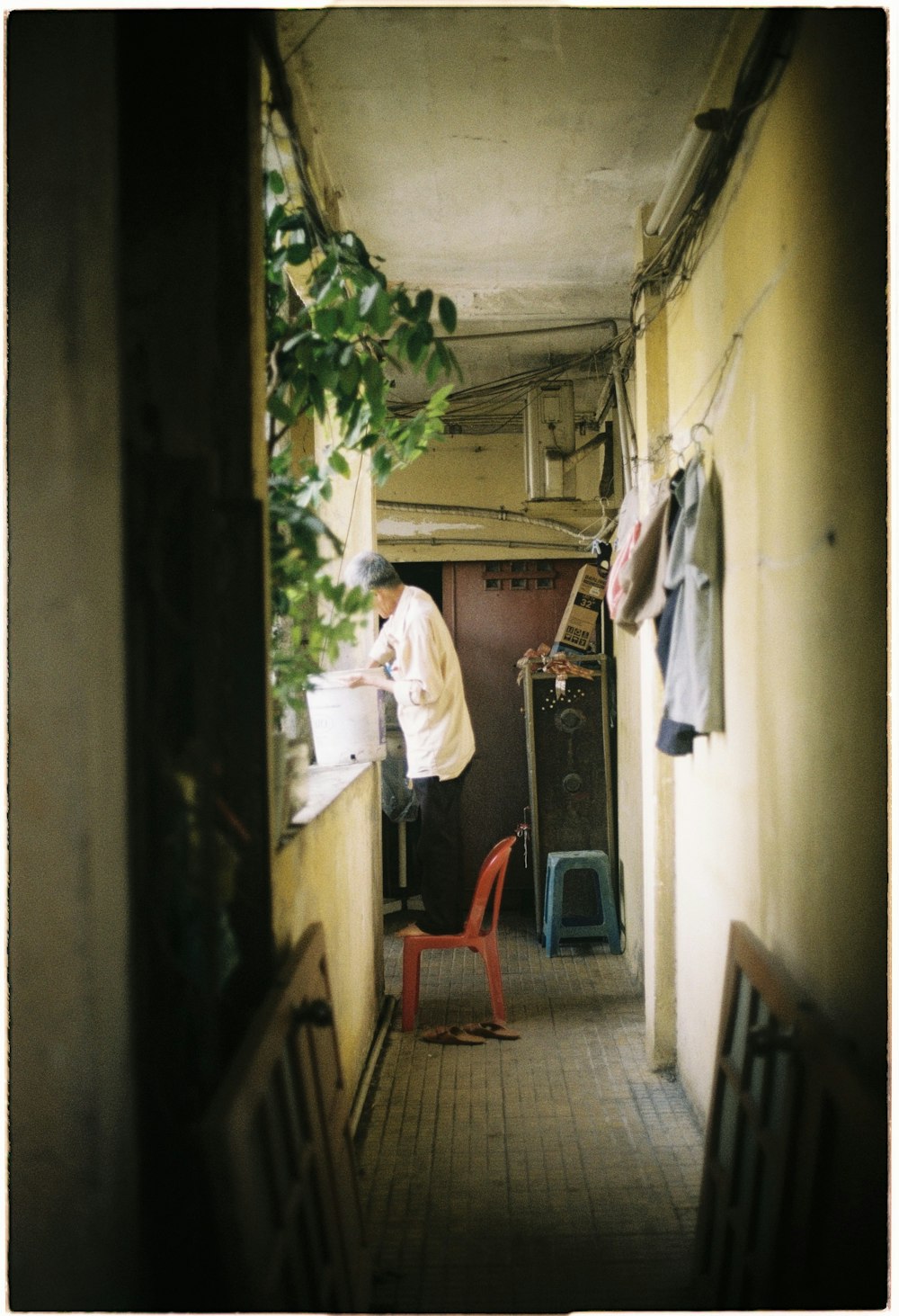 man in white dress shirt sitting on red plastic chair