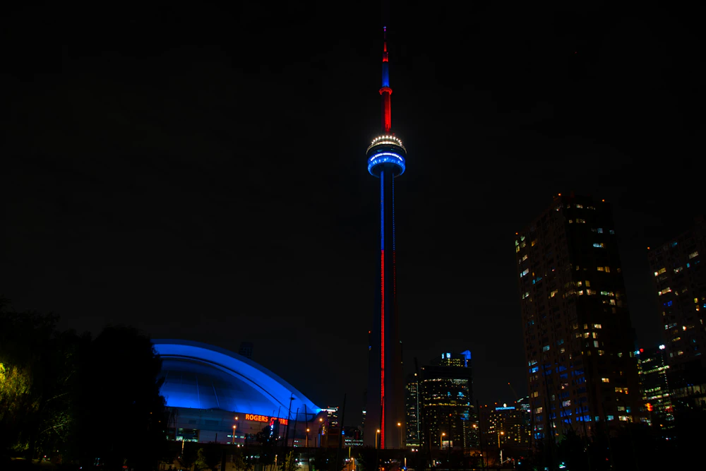 The CN Tower illuminated at night above the Toronto skyline