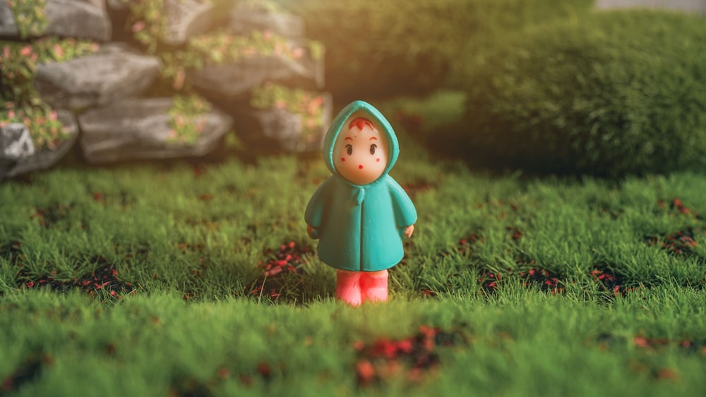 red haired girl in green dress figurine on green grass during daytime