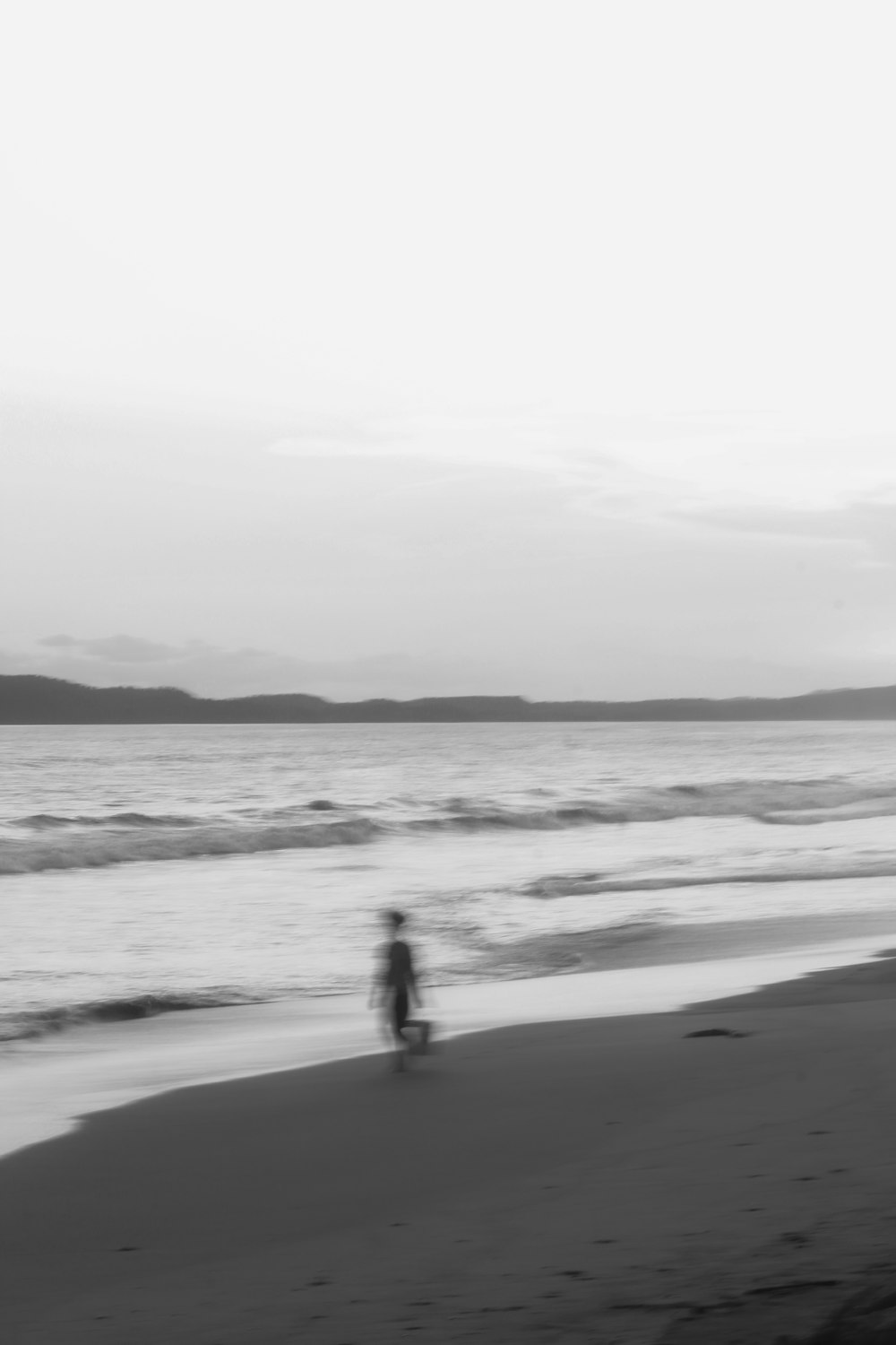 silhouette of 2 people walking on beach during daytime