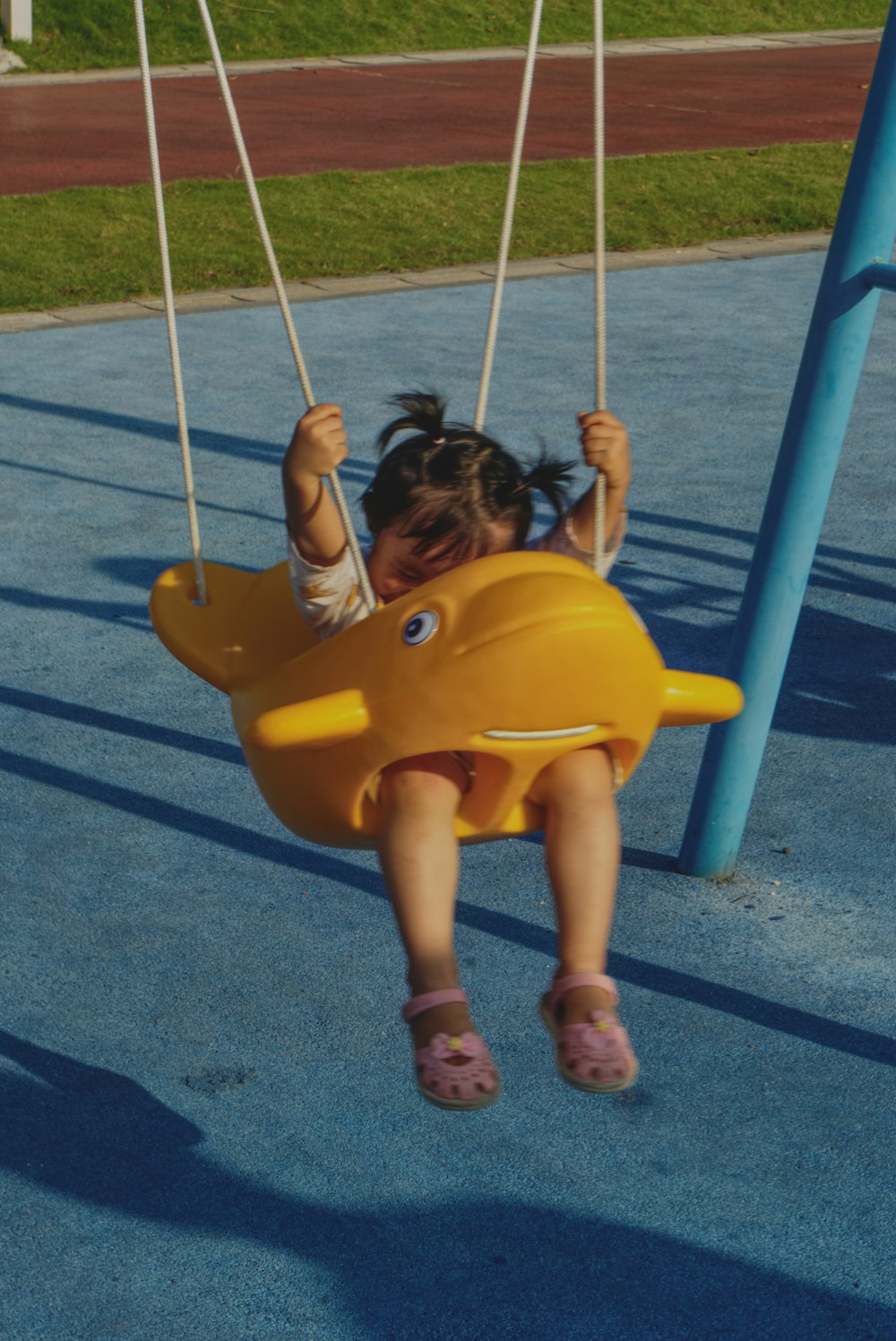 menina na camisa amarela sentada no balanço amarelo