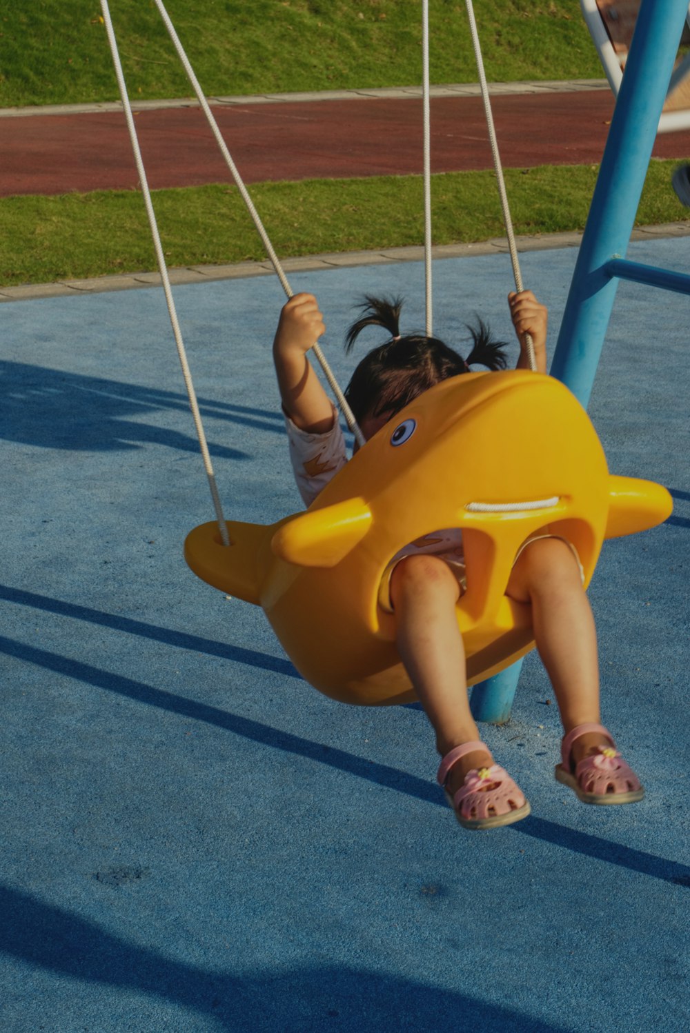 girl in yellow shirt riding yellow swing