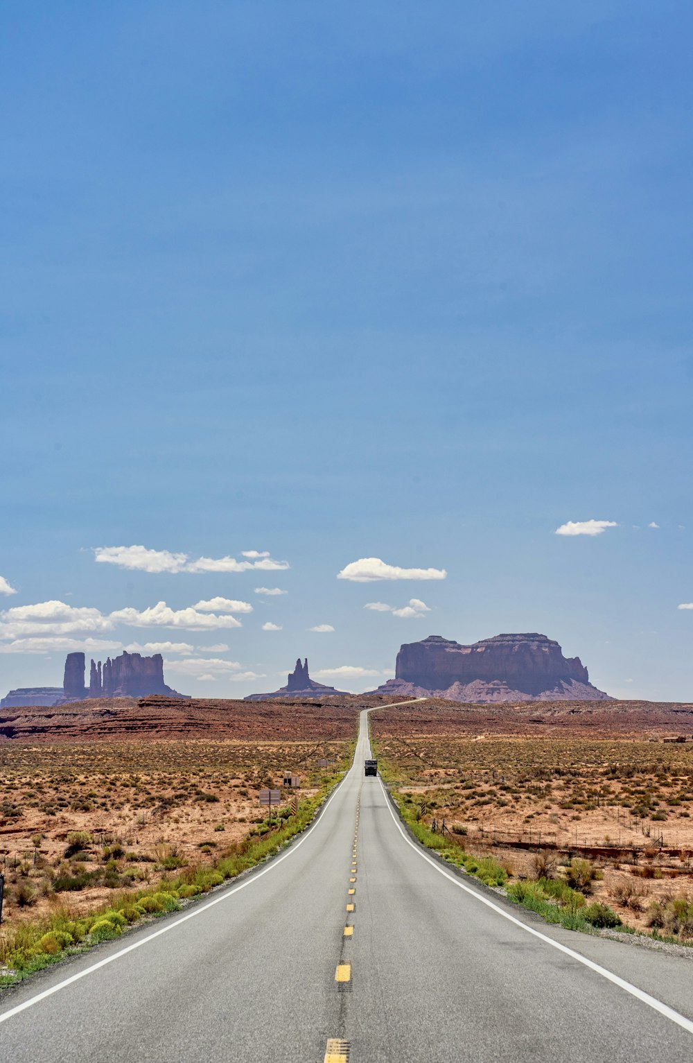 gray asphalt road in the middle of brown field under blue sky during daytime