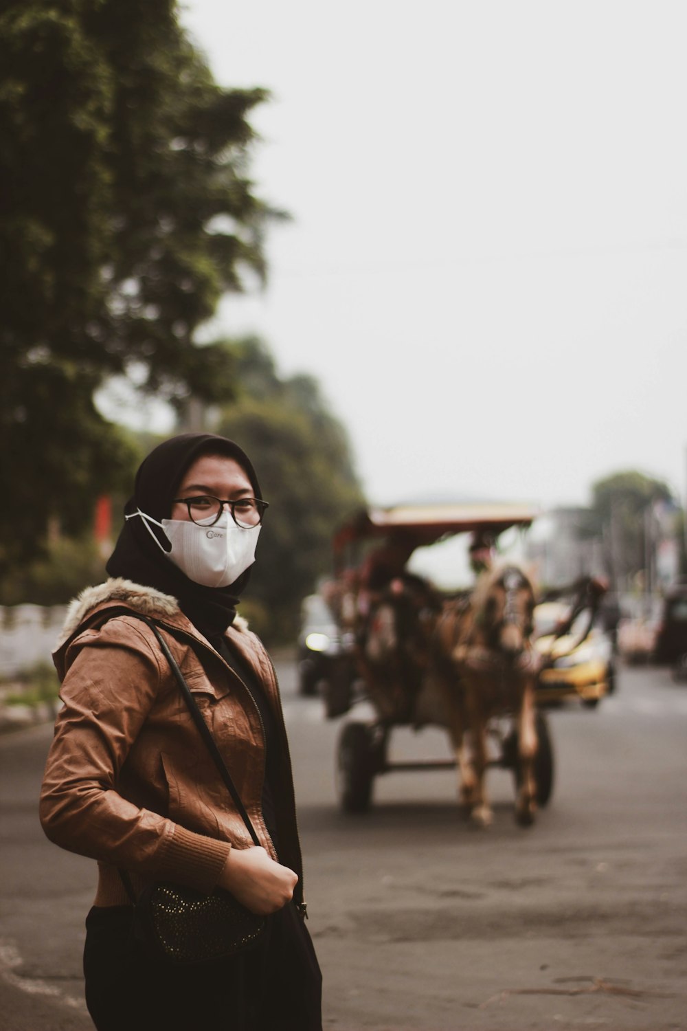 man in brown leather jacket wearing white mask