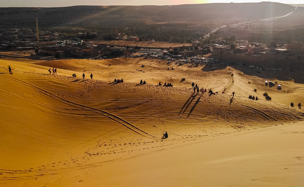 persone che camminano sul deserto durante il giorno