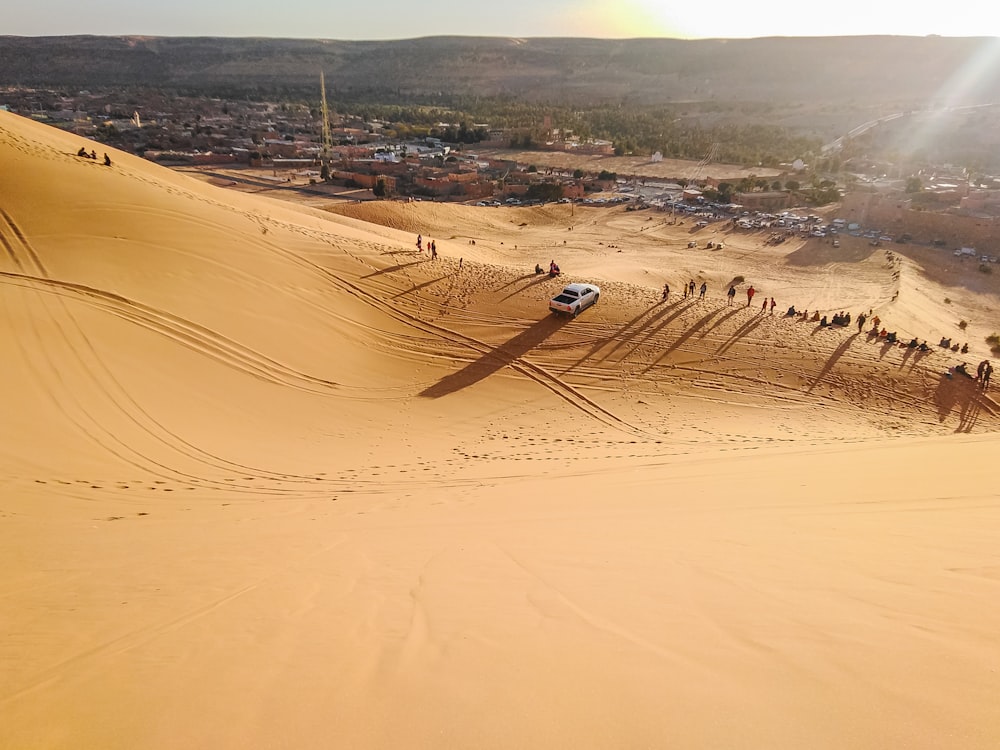 white and black helicopter flying over brown sand