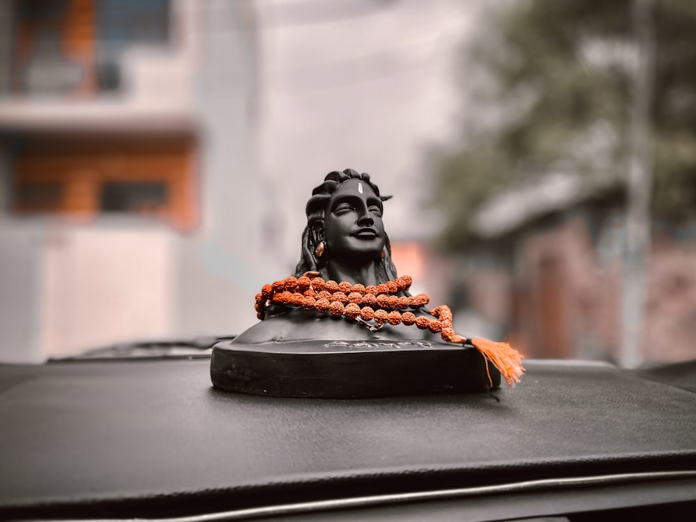 black ceramic bust on black car hood