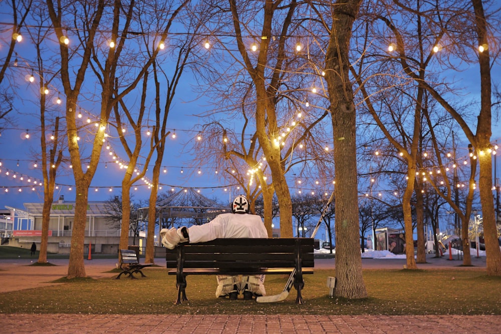 man and woman sitting on bench under brown tree during daytime