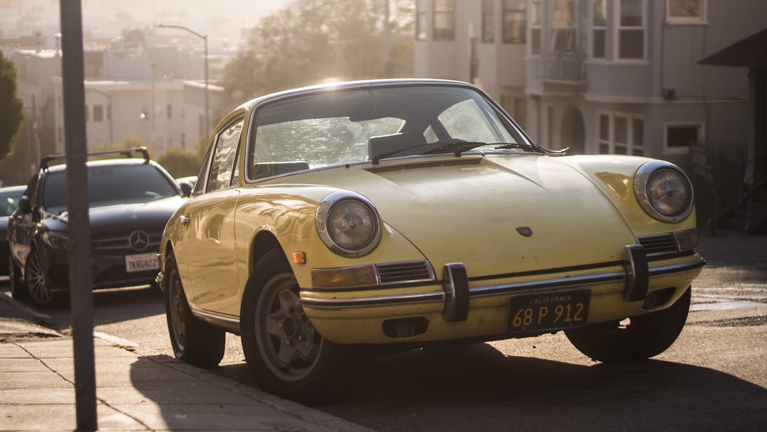 yellow classic car parked on the street