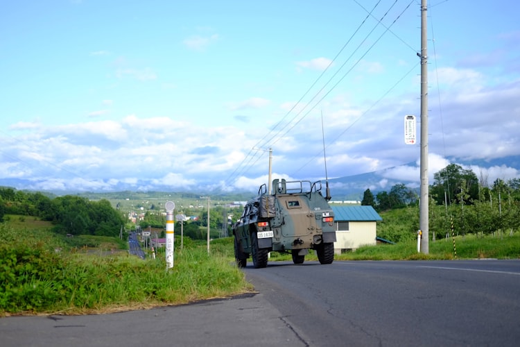 Japanese rural road through green countryside in Kumamoto Prefecture connecting One Piece statue locations