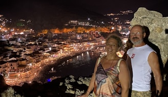 Couples enjoying a scenic cruise with city lights in the background at dusk.