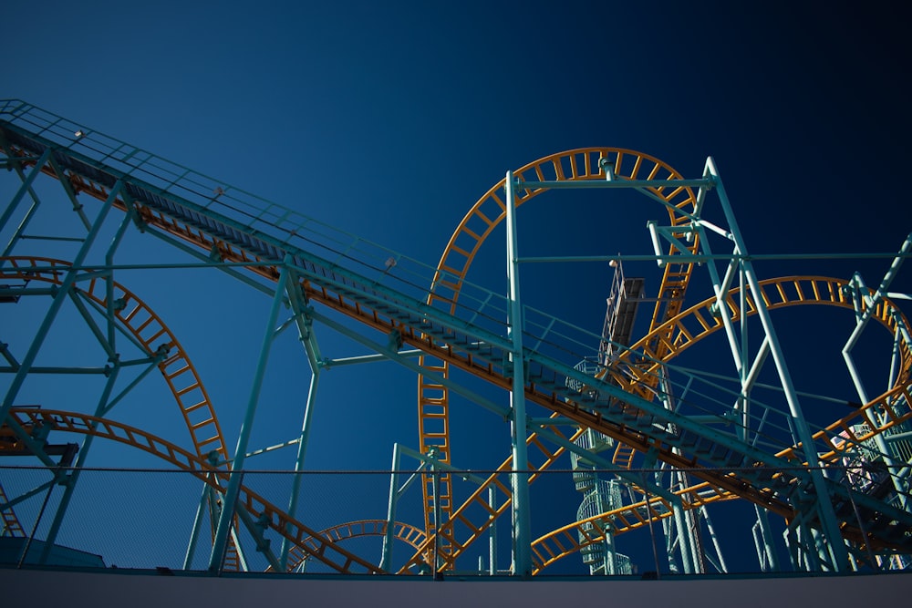 white and red roller coaster under blue sky during daytime