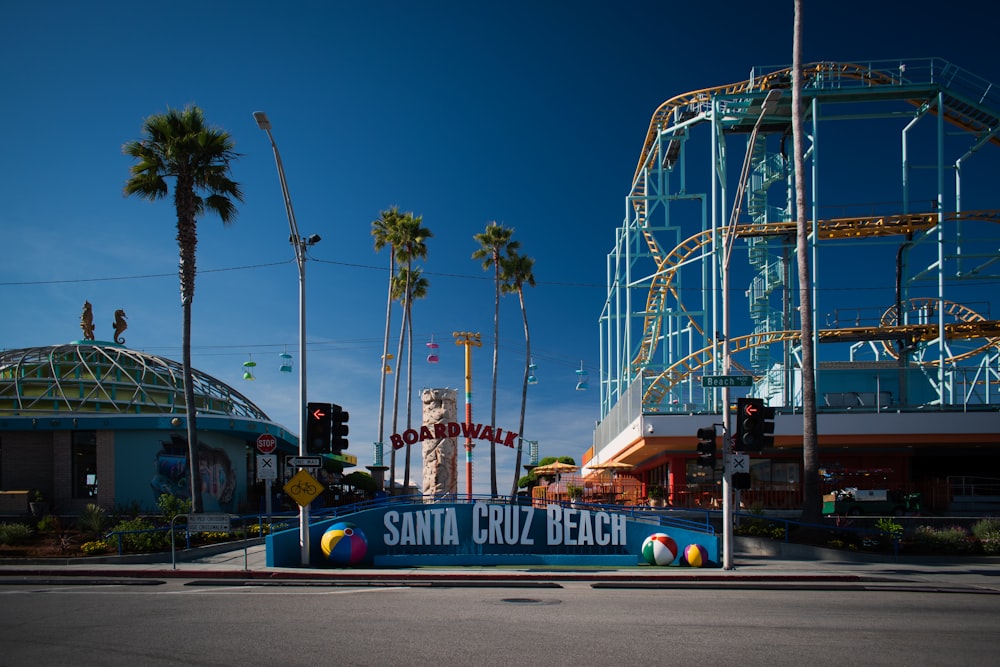 a santa cruz beach sign in front of a roller coaster