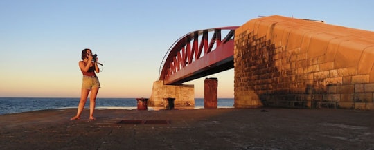 brown concrete bridge over the sea during daytime in Grand Harbour Malta