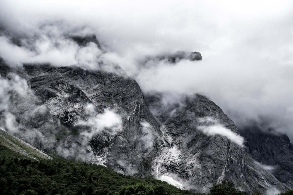 白い雲の下の灰色と白の山