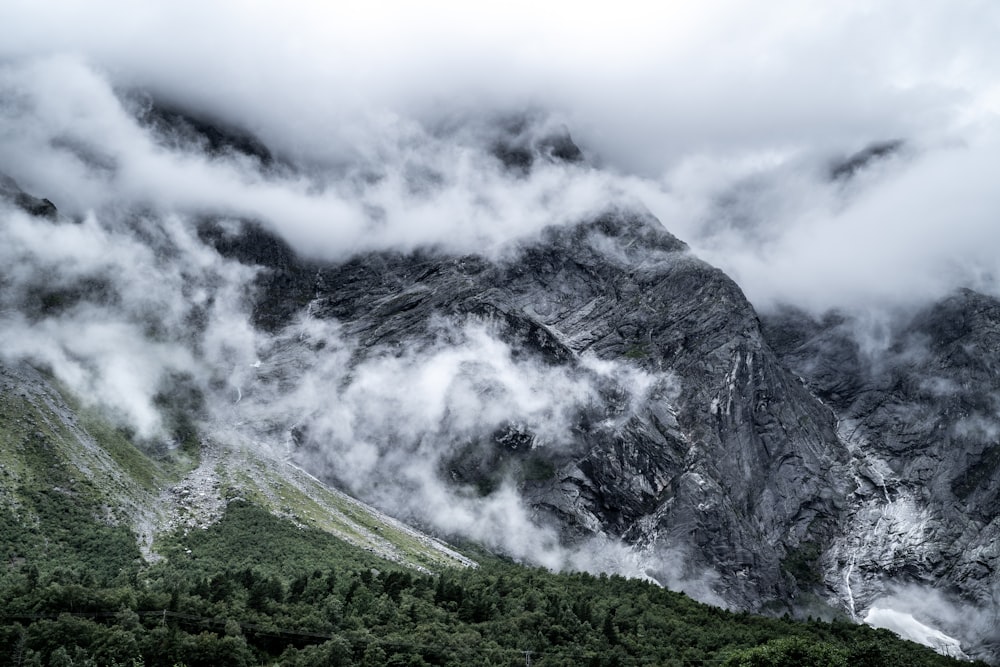 白い雲の下の緑と灰色の山