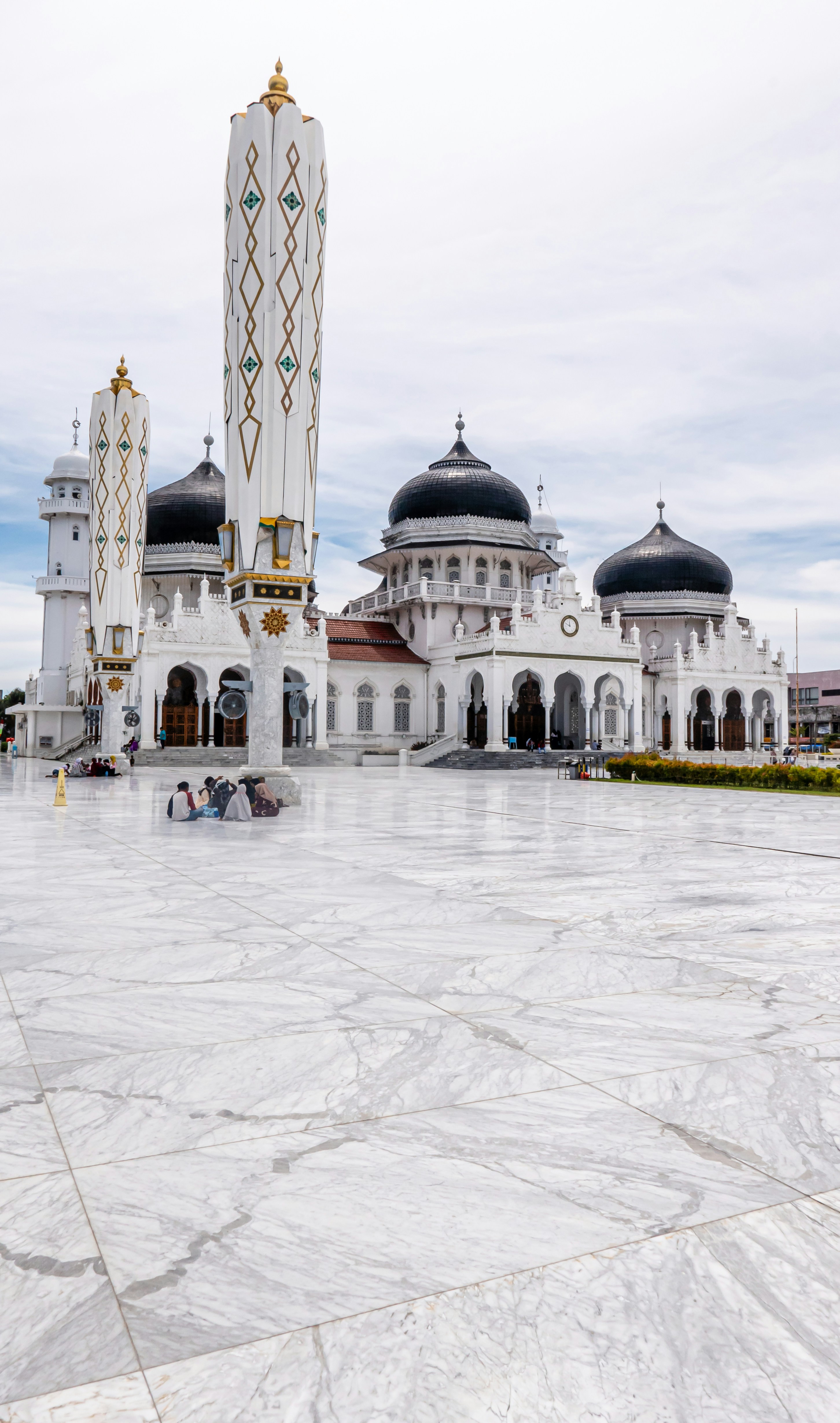 personas que caminan sobre edificios de concreto blanco y gris durante el día
