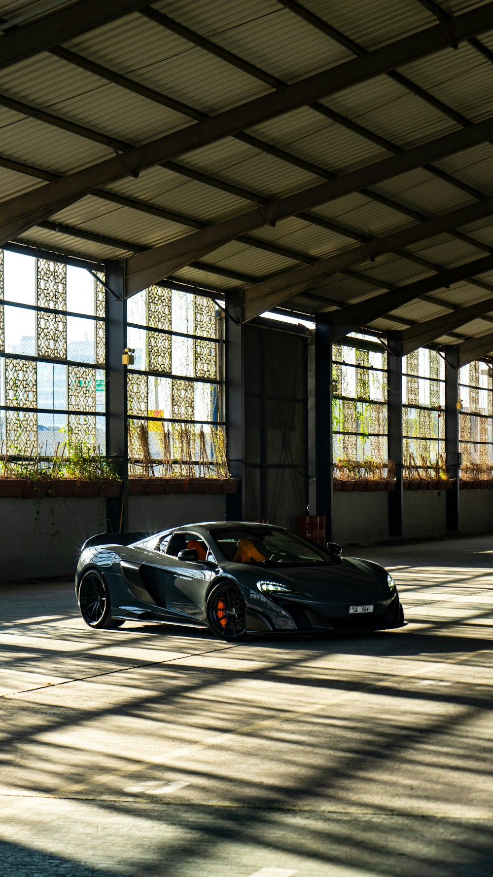 black porsche 911 parked in front of black metal gate