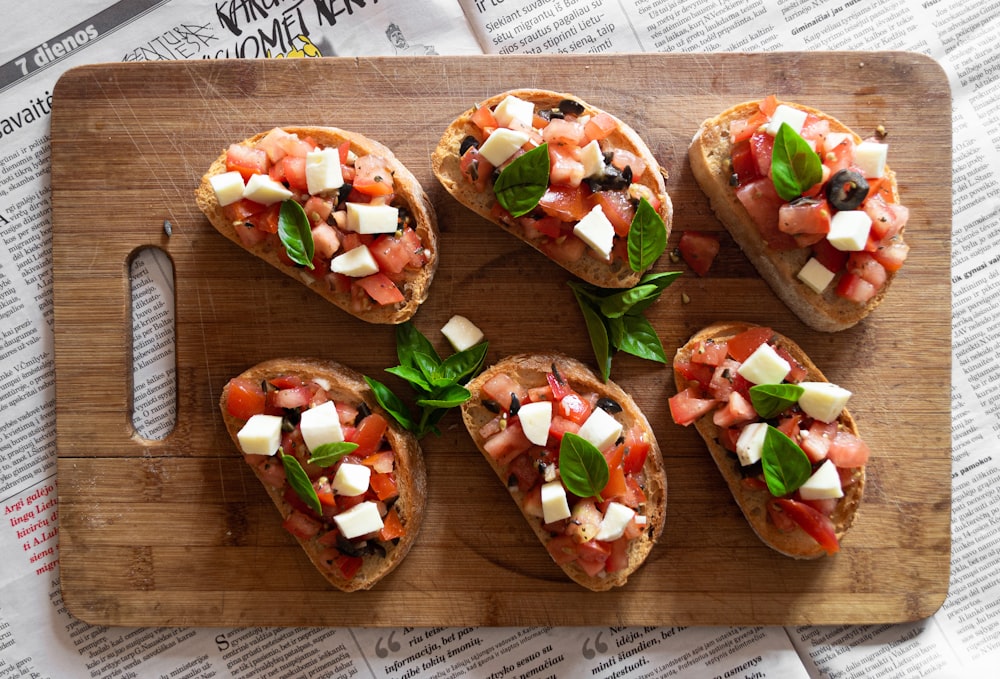 sliced tomato and green vegetable on brown wooden chopping board