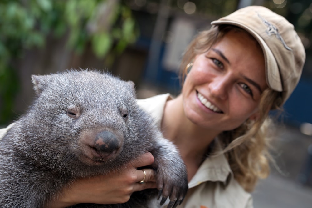 girl in white shirt holding gray animal