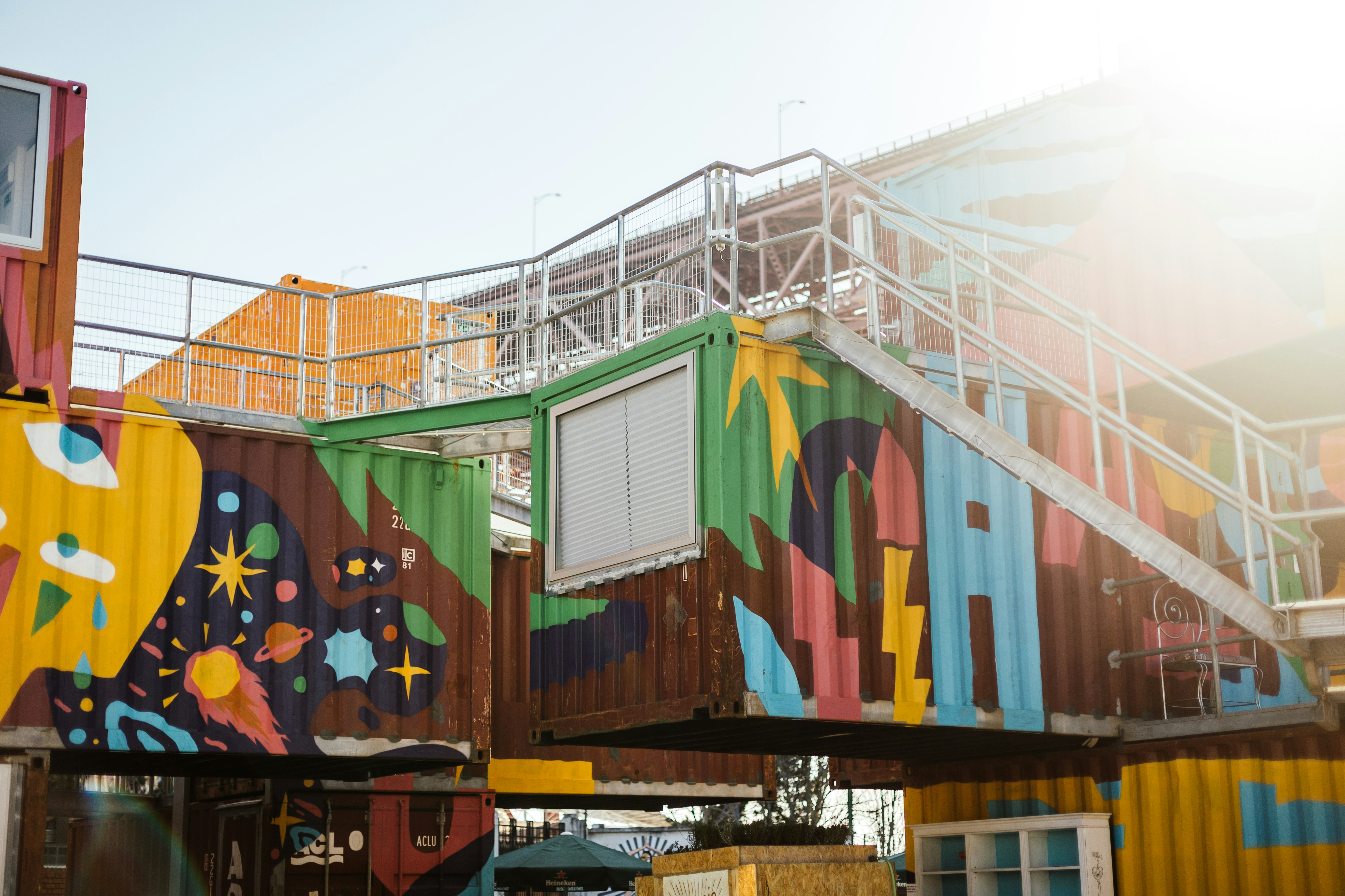 man in blue t-shirt standing beside blue and red building during daytime