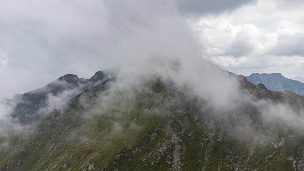 green trees on mountain under white clouds during daytime