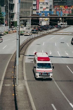 A sleek ambulance from Alfa Medical Transport Solution navigating city streets.