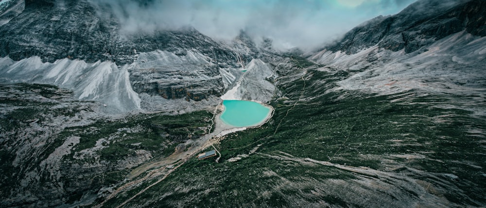 aerial view of lake in the middle of gray rocky mountain