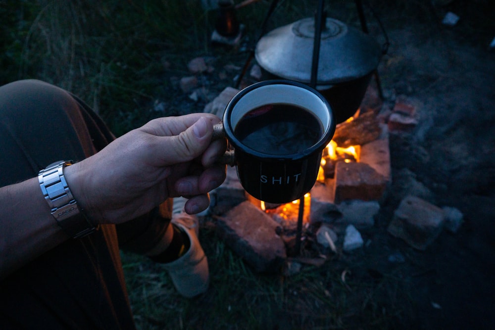 person holding black ceramic mug