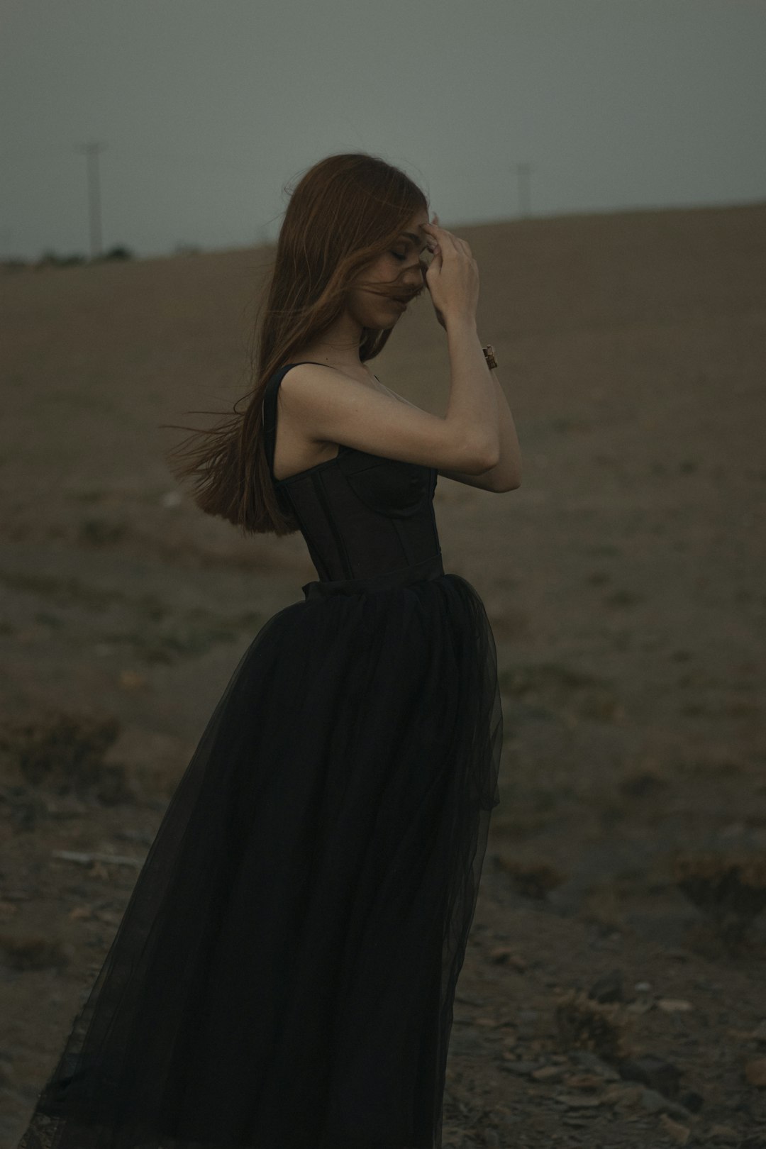 woman in black dress standing on brown sand during daytime