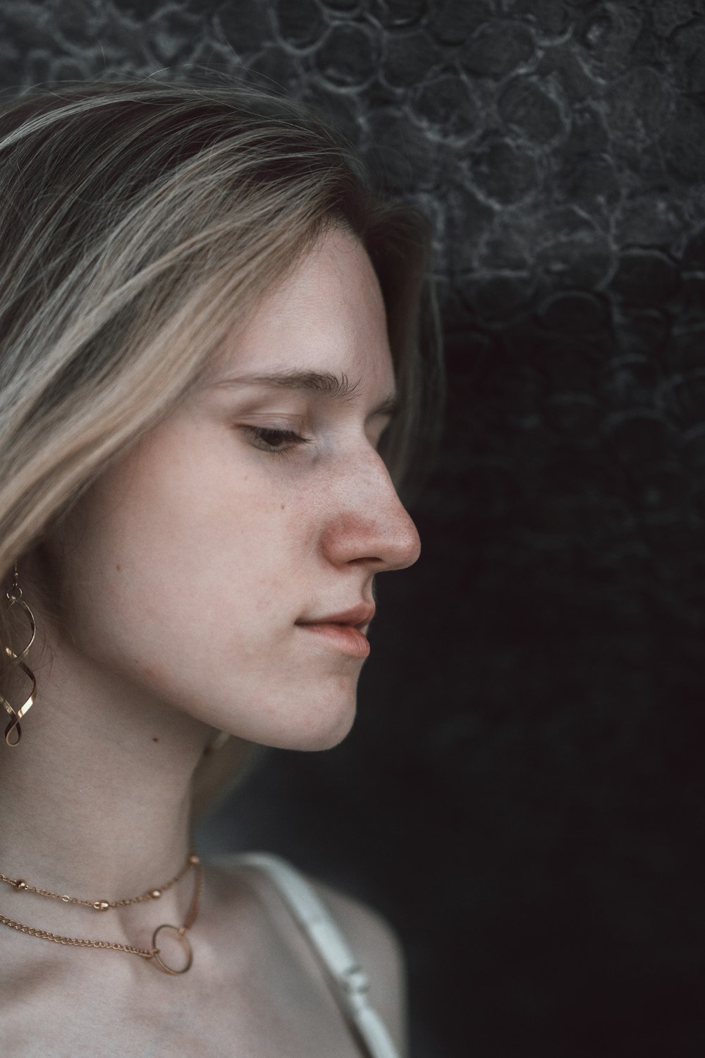 woman in silver necklace and silver earrings