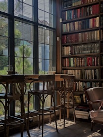 brown wooden chairs and table near window