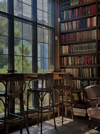 brown wooden chairs and table near window
