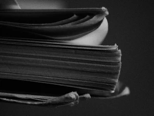 grayscale photo of stack of books