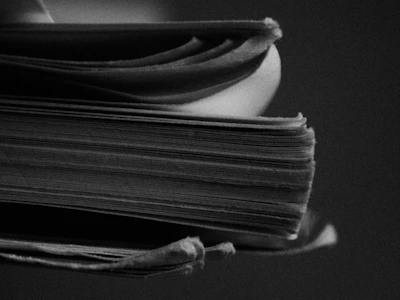 grayscale photo of stack of books