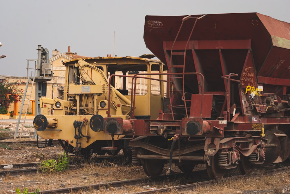 yellow and red train on rail tracks during daytime