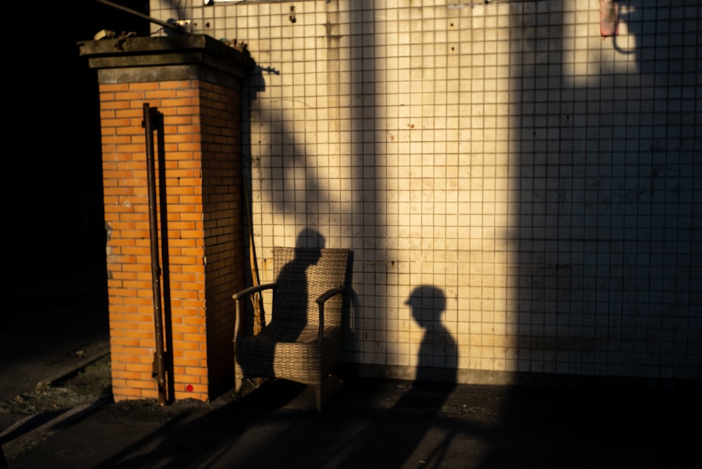 silhouette of 2 person standing near white wall