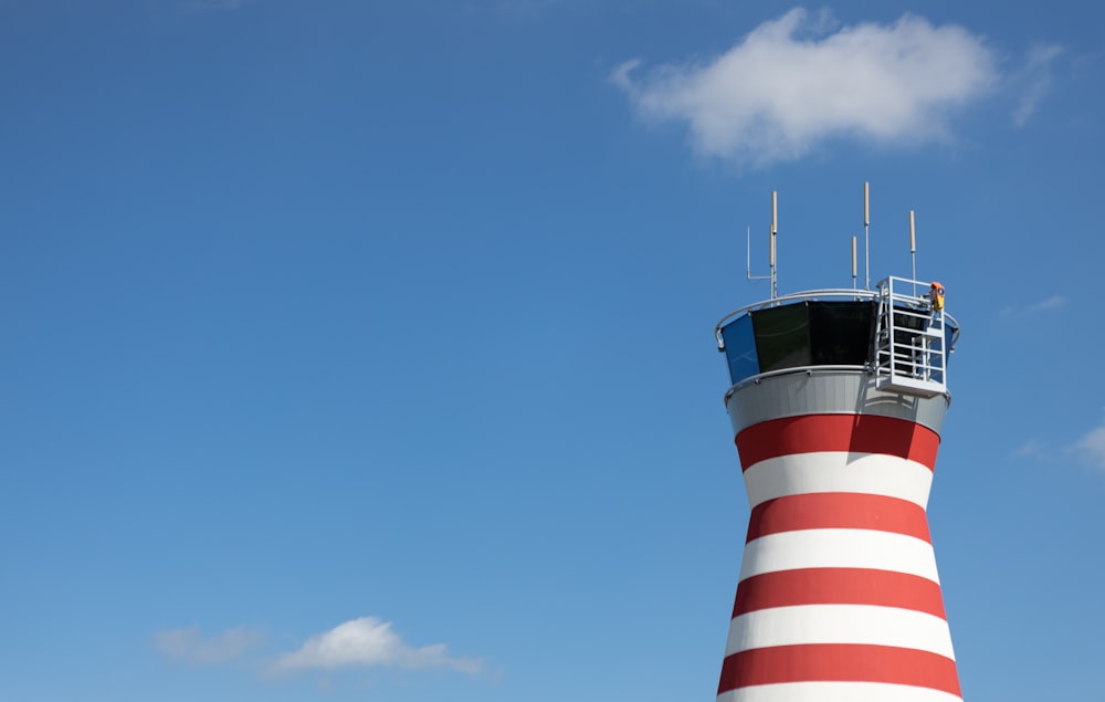 white and red striped lighthouse under blue sky during daytime